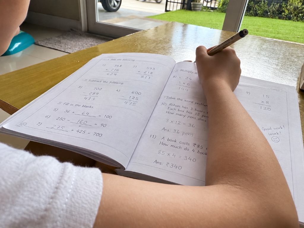 Child working through Maths problems in a workbook